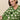 Woman wearing a green warm and wonderful sweater with sheep pattern on a beige background