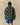 Back view of a person wearing a dark green Sheep Sherpa Jacket by Warm & Wonderful, featuring a white sheep pattern reminiscent of the iconic Princess Diana black sheep sweater.