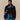 A person wears the Paddington Sherpa Jacket Navy by Rowing Blazers x Paddington™ with blue athletic shorts, standing against a beige background.