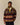 A man wearing a Rowing Blazers Fair Isle Clark Sherpa Multi-Color pullover with a yellow snap-button placket and stand-up collar.