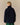 Back view of a person wearing a navy blue Rowing Blazers Clark Sherpa Navy pullover with a purple inner collar.