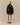 Tuxedo Paddington Classic Sherpa Black jacket with a repeating Paddington Bear print, worn with a plaid skirt.