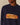 A person wearing the Rowing Blazers Cotton NY Hot Dog Sweater Navy, an oversized intarsia-knit sweater featuring a hot dog graphic with “NEW YORK” in mustard across the sausage.