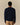 A person seen from the back wearing a dark blue Paddington Cotton Text Sweater Navy crewneck sweater by Rowing Blazers x Paddington™ and tan trousers.