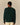 Back view of a person wearing a dark green Paddington Cashmere Sweater Green and cream-colored pants.