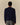 A person seen from the back, wearing a navy blue Paddington Bear Cashmere Sweater and grey trousers.