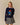 A person wearing a navy blue Rowing Blazers x Paddington™ Penelope Paddington Cashmere Sweater featuring an intarsia knit of Paddington Bear holding a jar of marmalade.